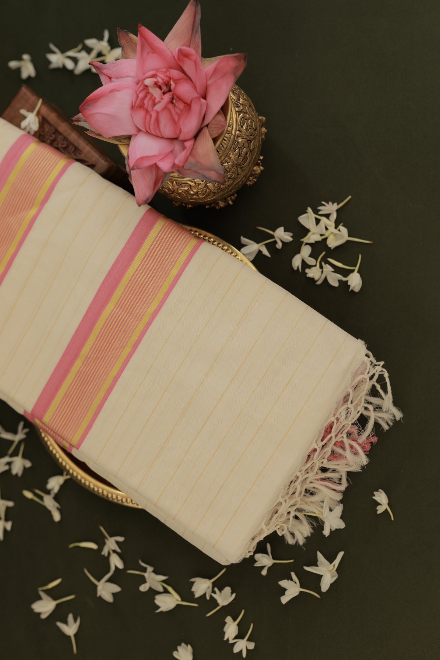 Pure Handloom Pink Striped Kasavu Saree folded flat, showing the lotus pink kara and golden kasavu stripes