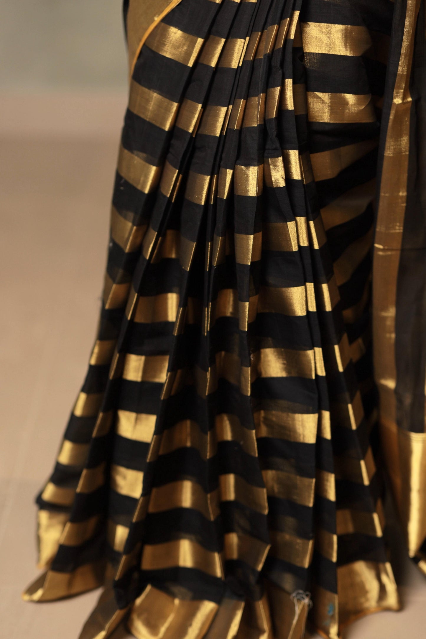 Detail of the pleats showing the gold kasavu weave and black stripes of the handloom cotton saree